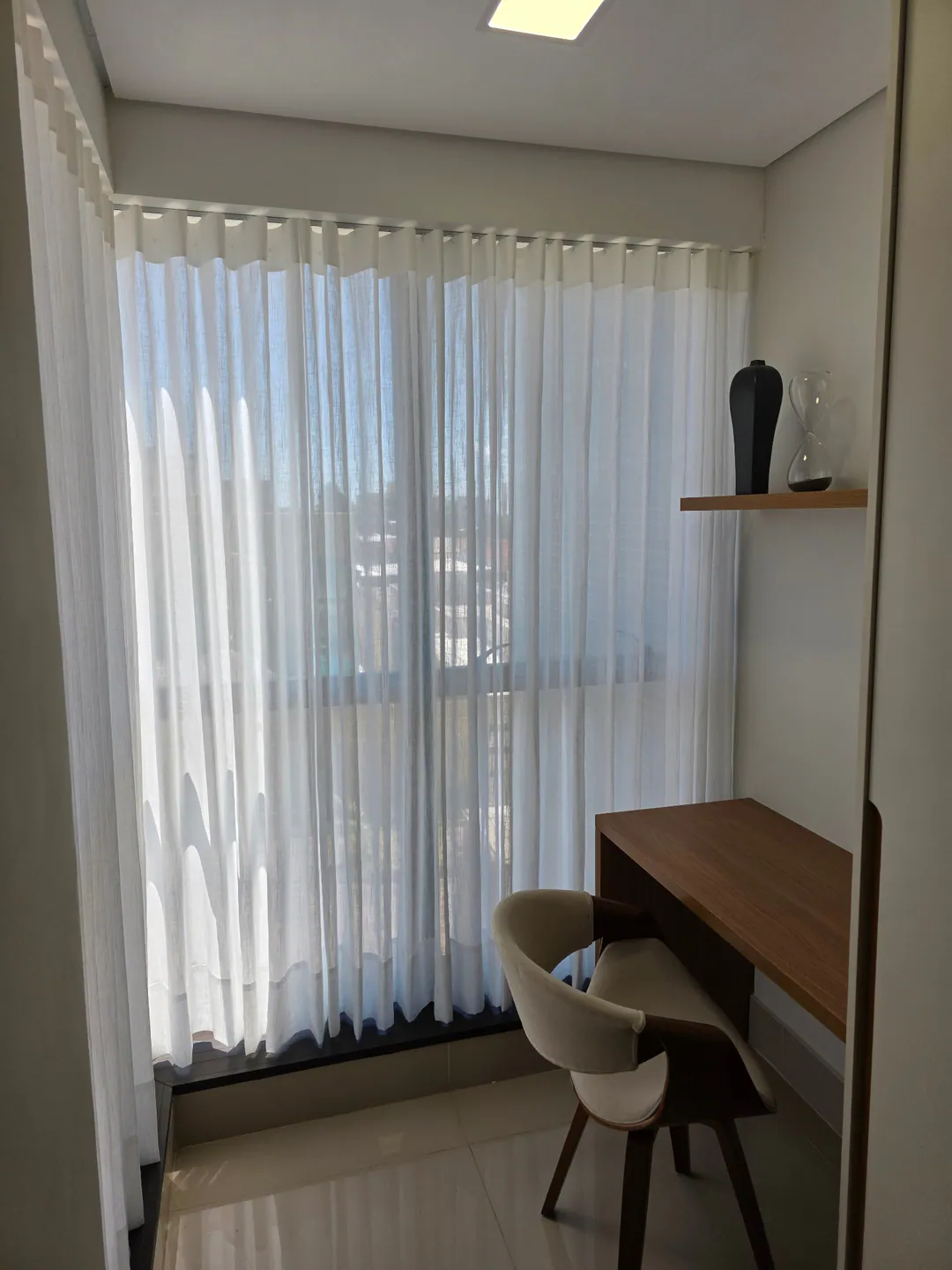 Cortina leve junto a uma mesa de trabalho