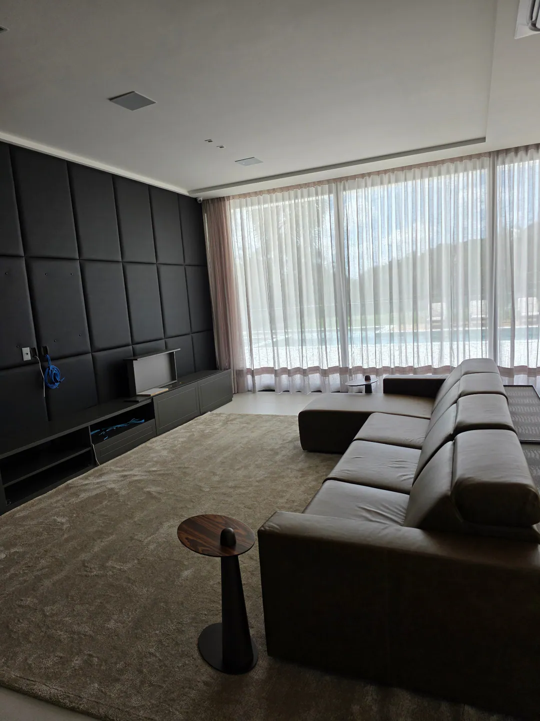 Cortinas em sala com painel de televisao