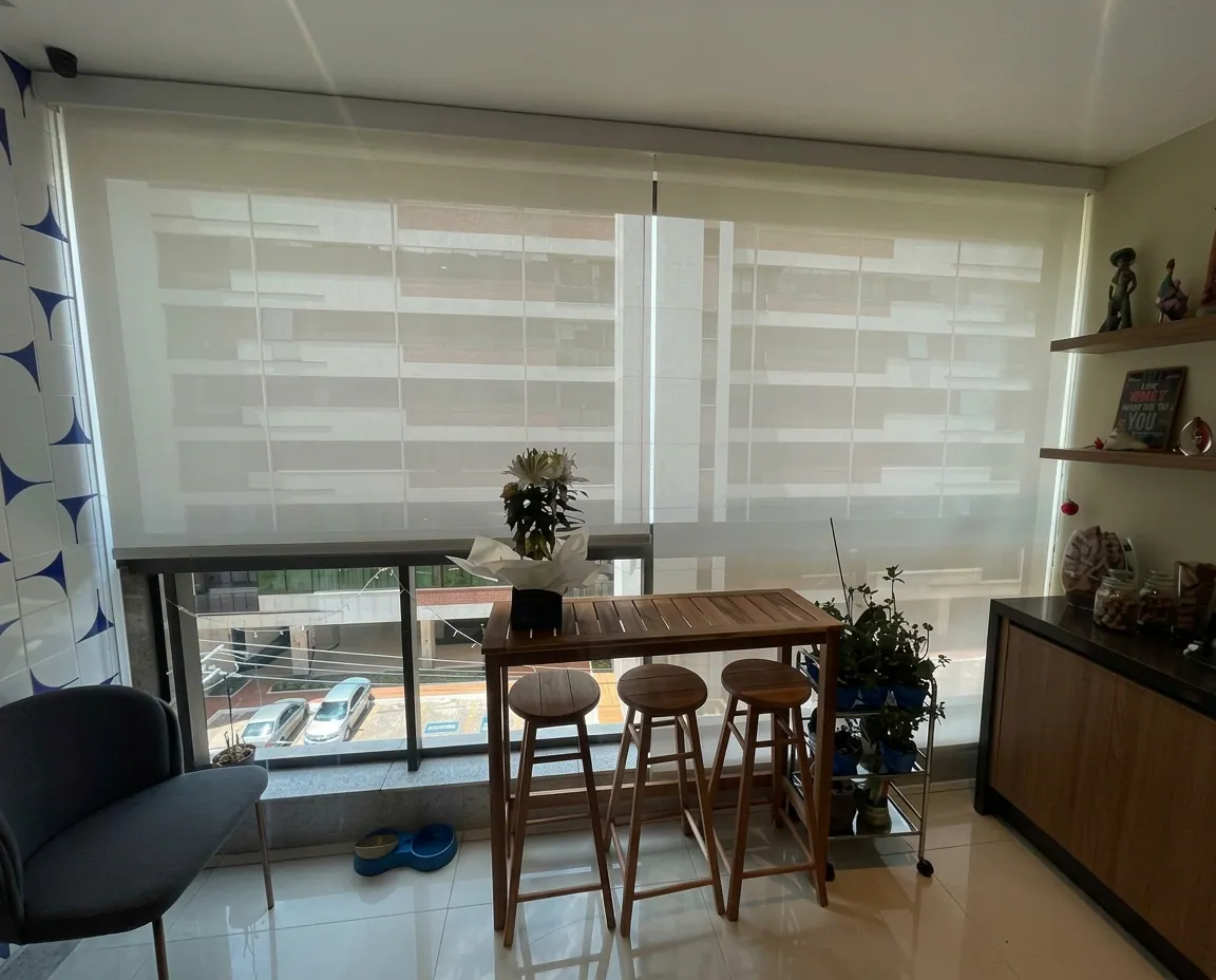 Persiana rolô tela solar em varanda com mesa de madeira